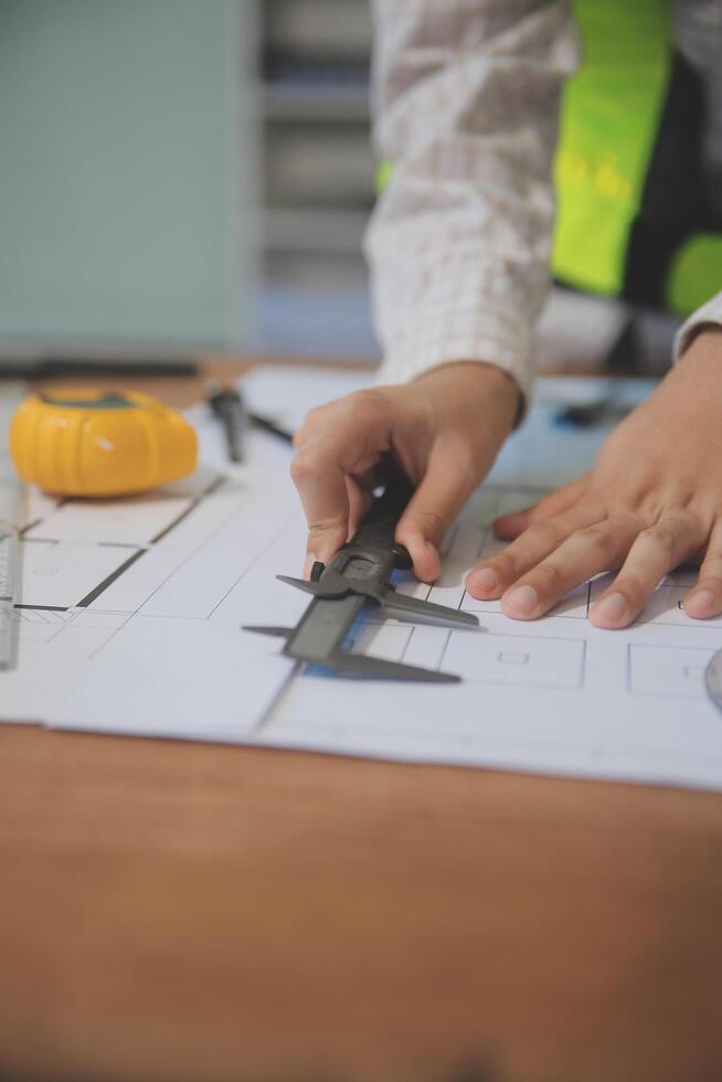 engineer people meeting working and pointing at a blueprint in office for discussing. Engineering tools and construction concept photo