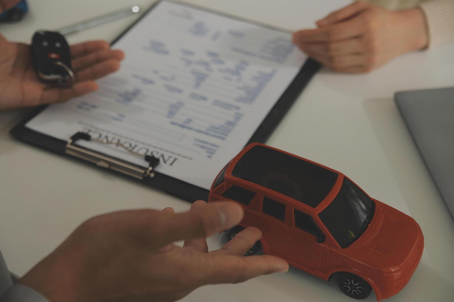 Young man receives a key from car salesman. After agreeing to a contract for rent or sale of a car at workshop, loan car, insurance, sale, buying car and finance concept. photo