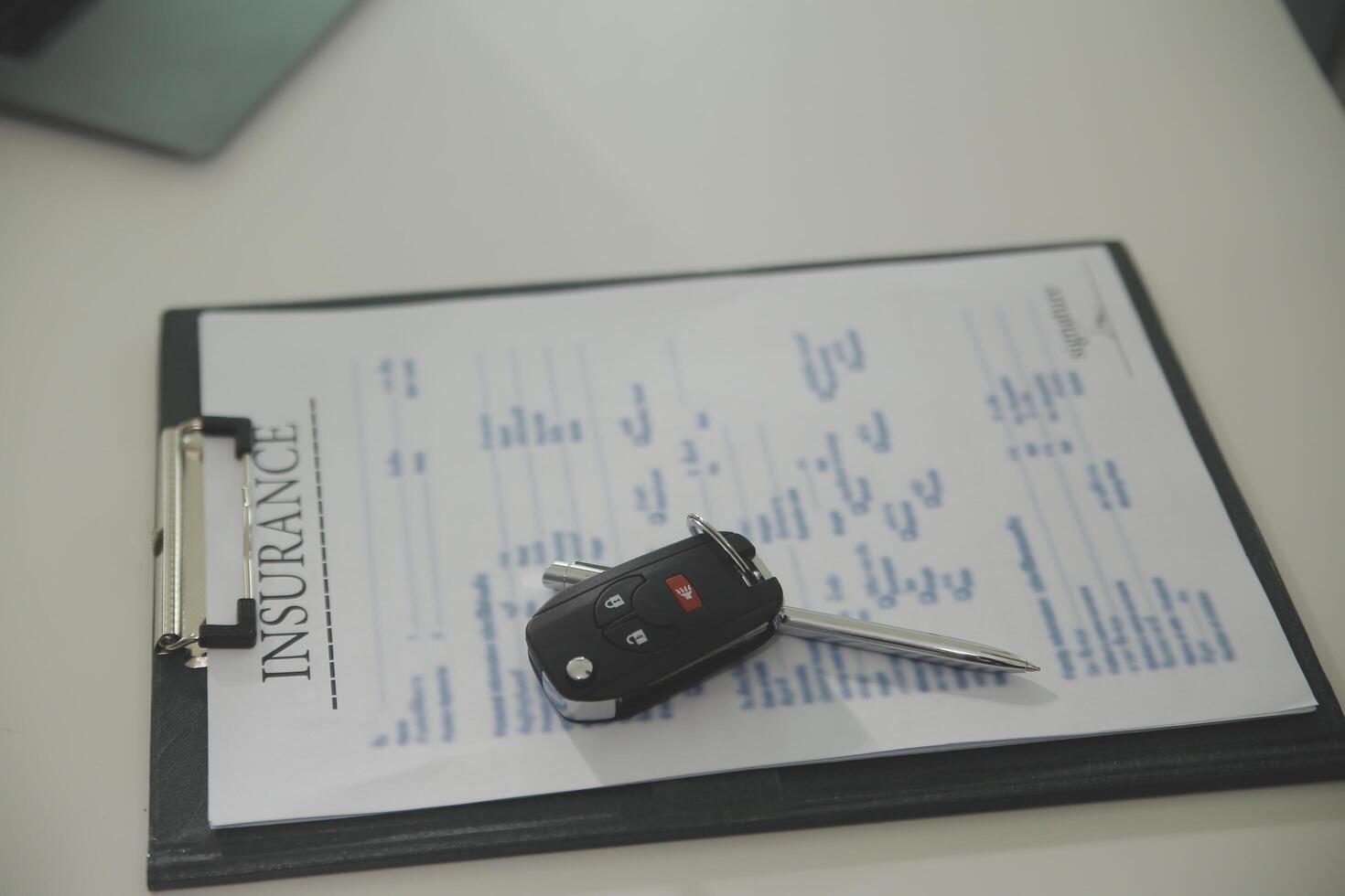 Young man receives a key from car salesman. After agreeing to a contract for rent or sale of a car at workshop, loan car, insurance, sale, buying car and finance concept. photo