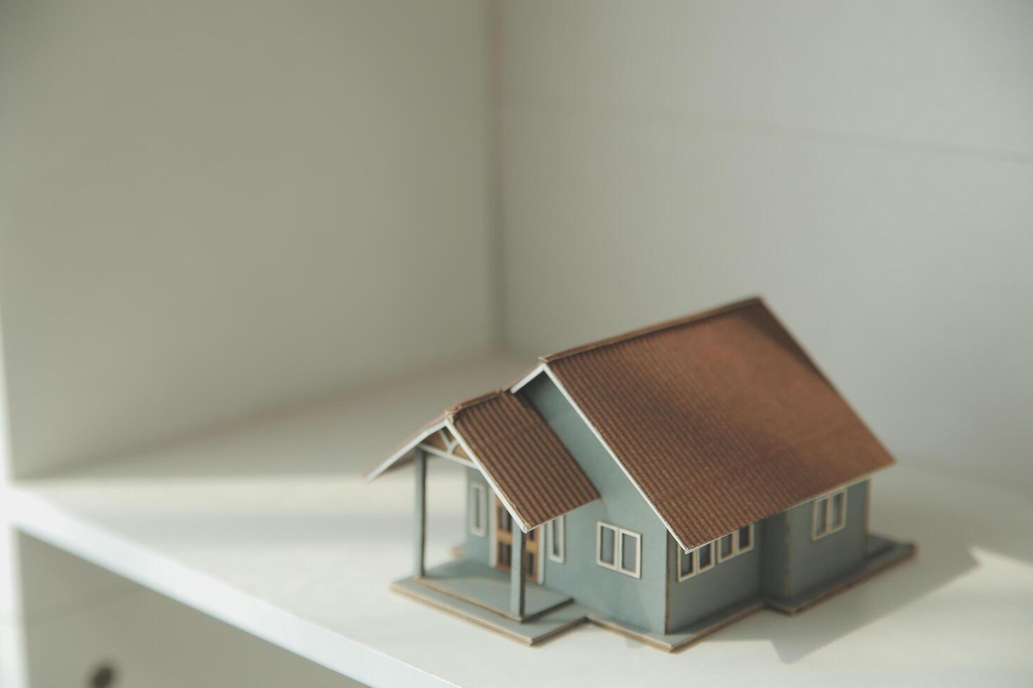 Real estate agent home sales broker is using a pen pointing to the house model and explains the business contract, rent, buy, mortgage, loan, or home insurance photo