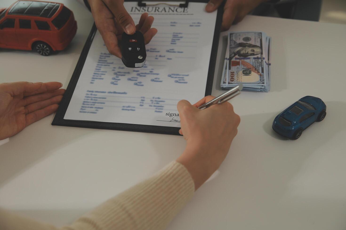 Young man receives a key from car salesman. After agreeing to a contract for rent or sale of a car at workshop, loan car, insurance, sale, buying car and finance concept. photo