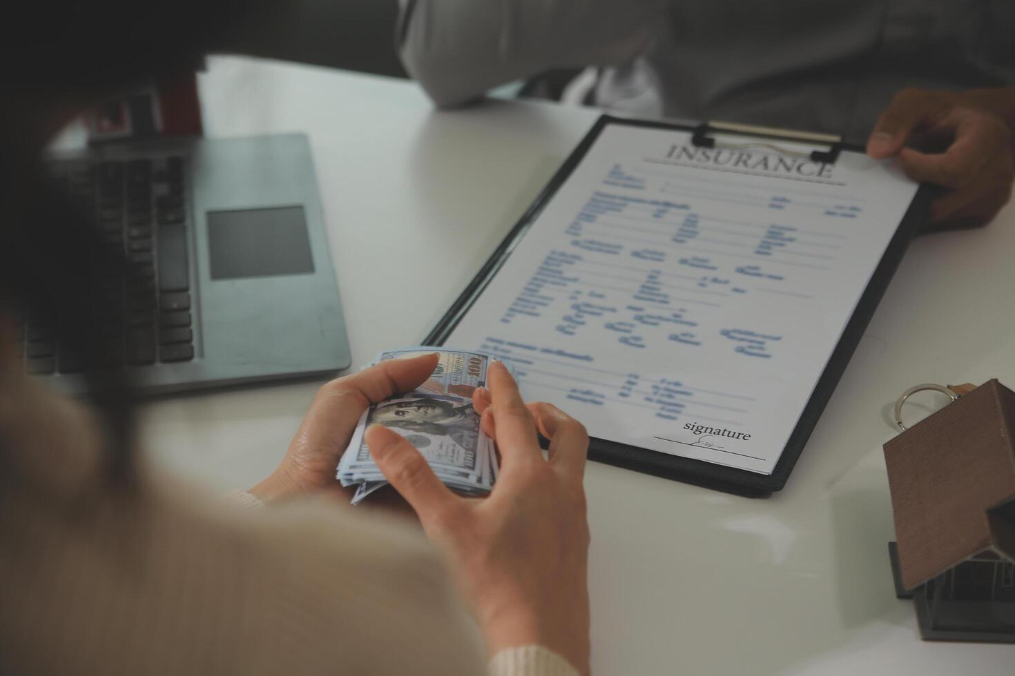 Real estate agent home sales broker is using a pen pointing to the house model and explains the business contract, rent, buy, mortgage, loan, or home insurance photo