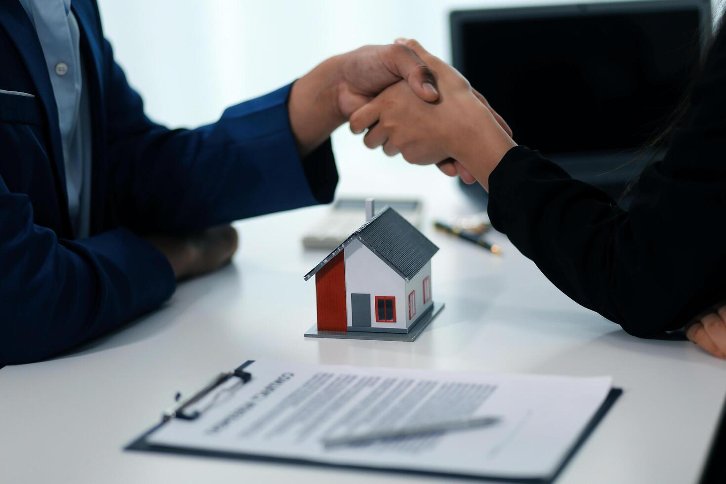 Estate agent shaking hands with customer after contract signature photo