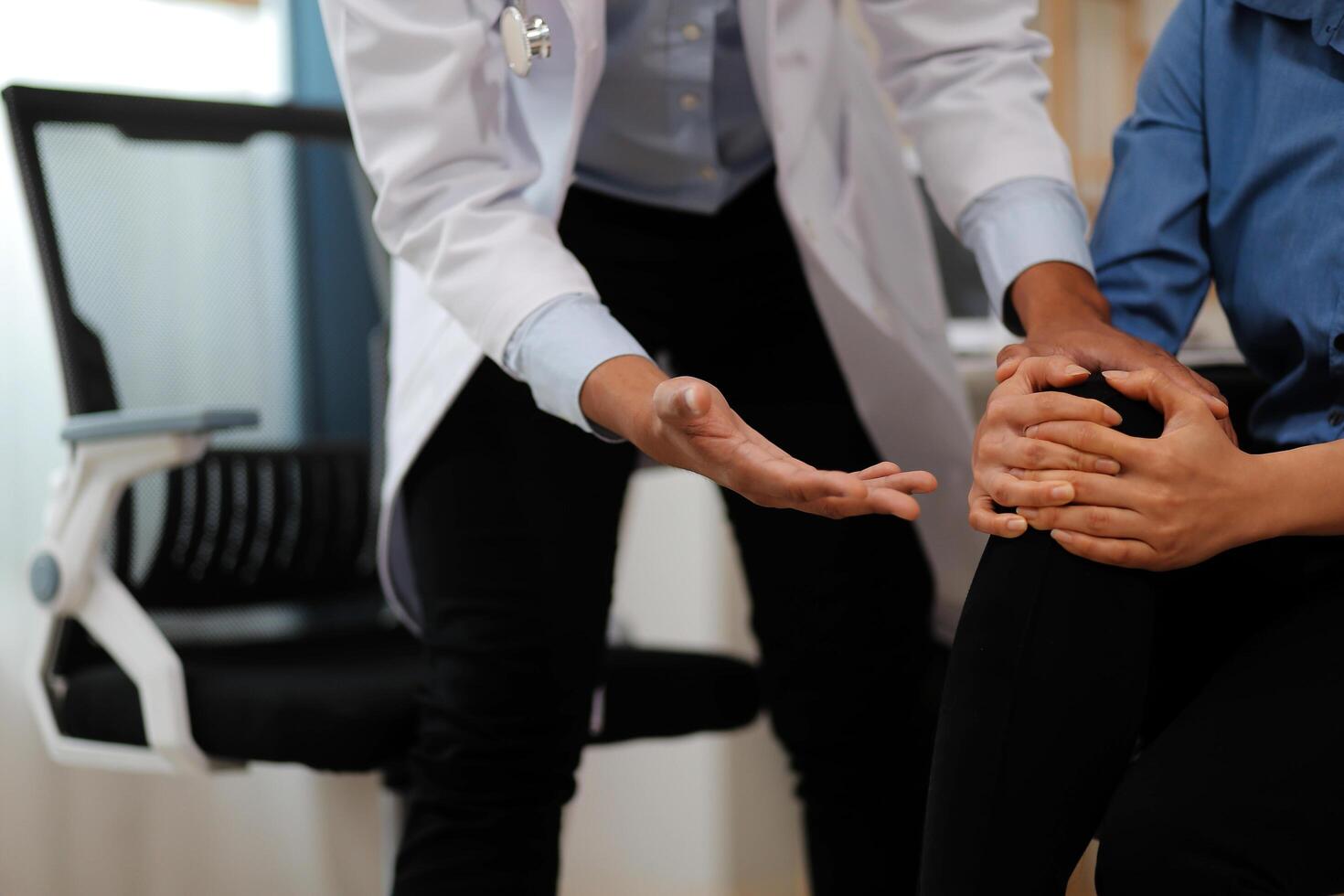 Professional orthopedist examining the little patient's leg in the clinic. Patient at the physiotherapy doing physical exercises with his therapist photo
