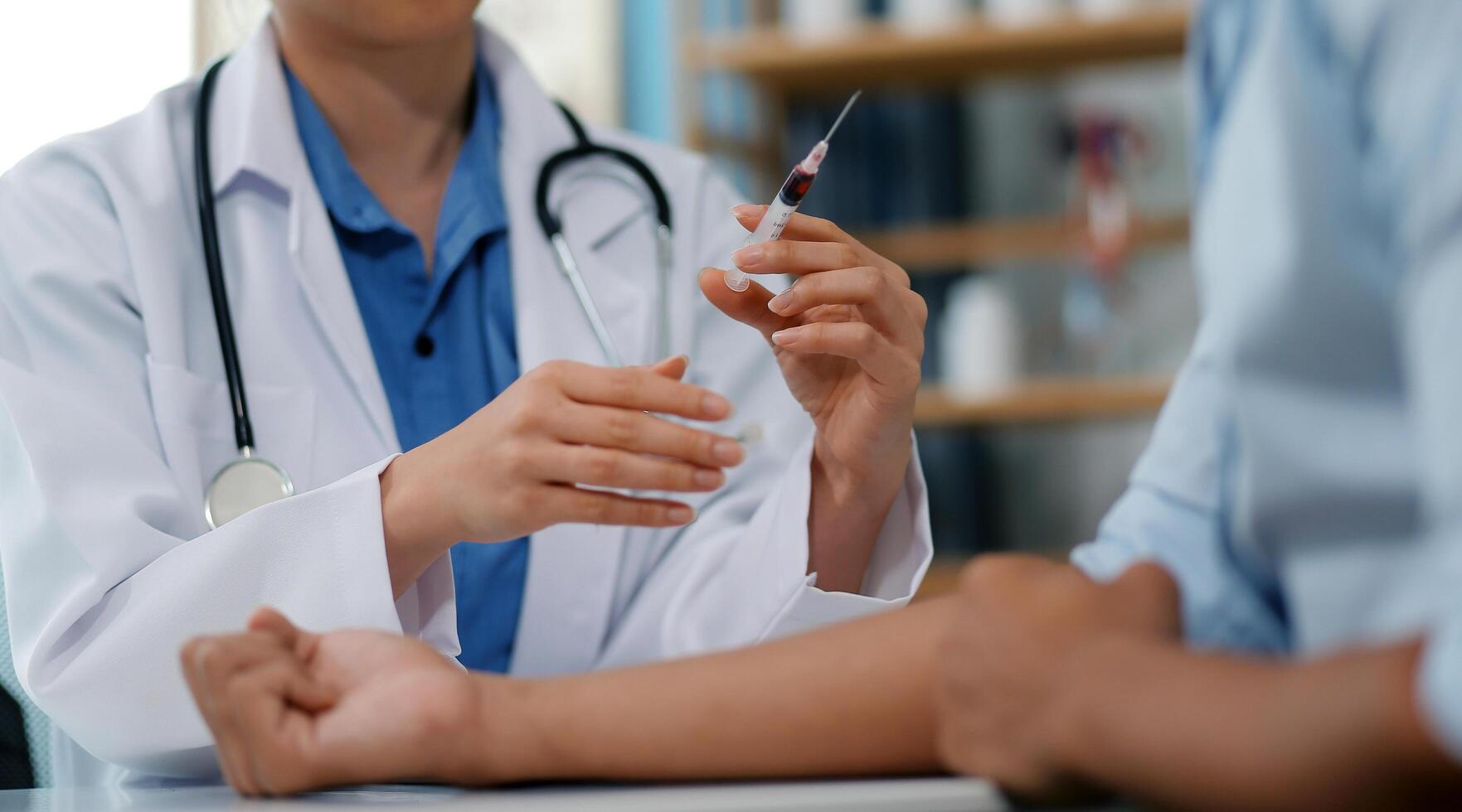 Doctor uses hypodermic needle and syringe to put a dose of medicine as treatment. photo