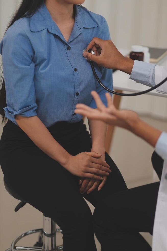 Asian doctor is using a stethoscope listen to the heartbeat of the elderly patient. photo