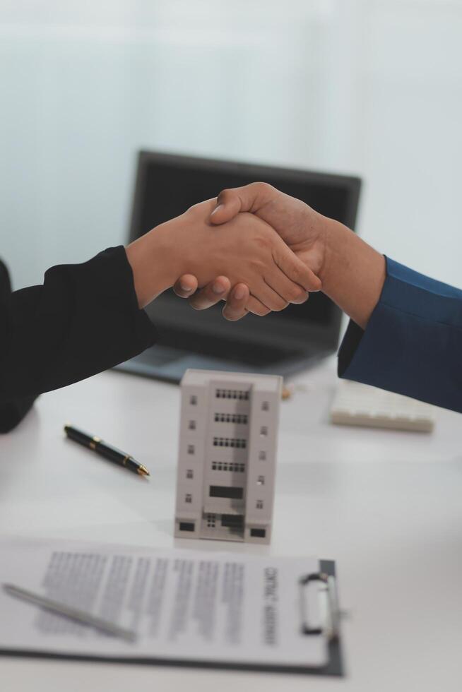 Estate agent shaking hands with customer after contract signature photo