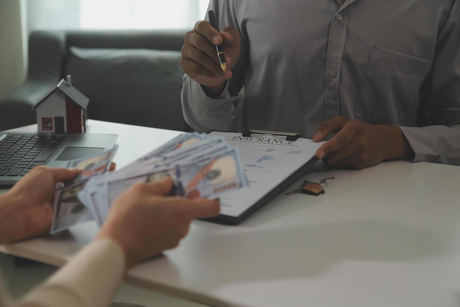 Real estate agent home sales broker is using a pen pointing to the house model and explains the business contract, rent, buy, mortgage, loan, or home insurance photo