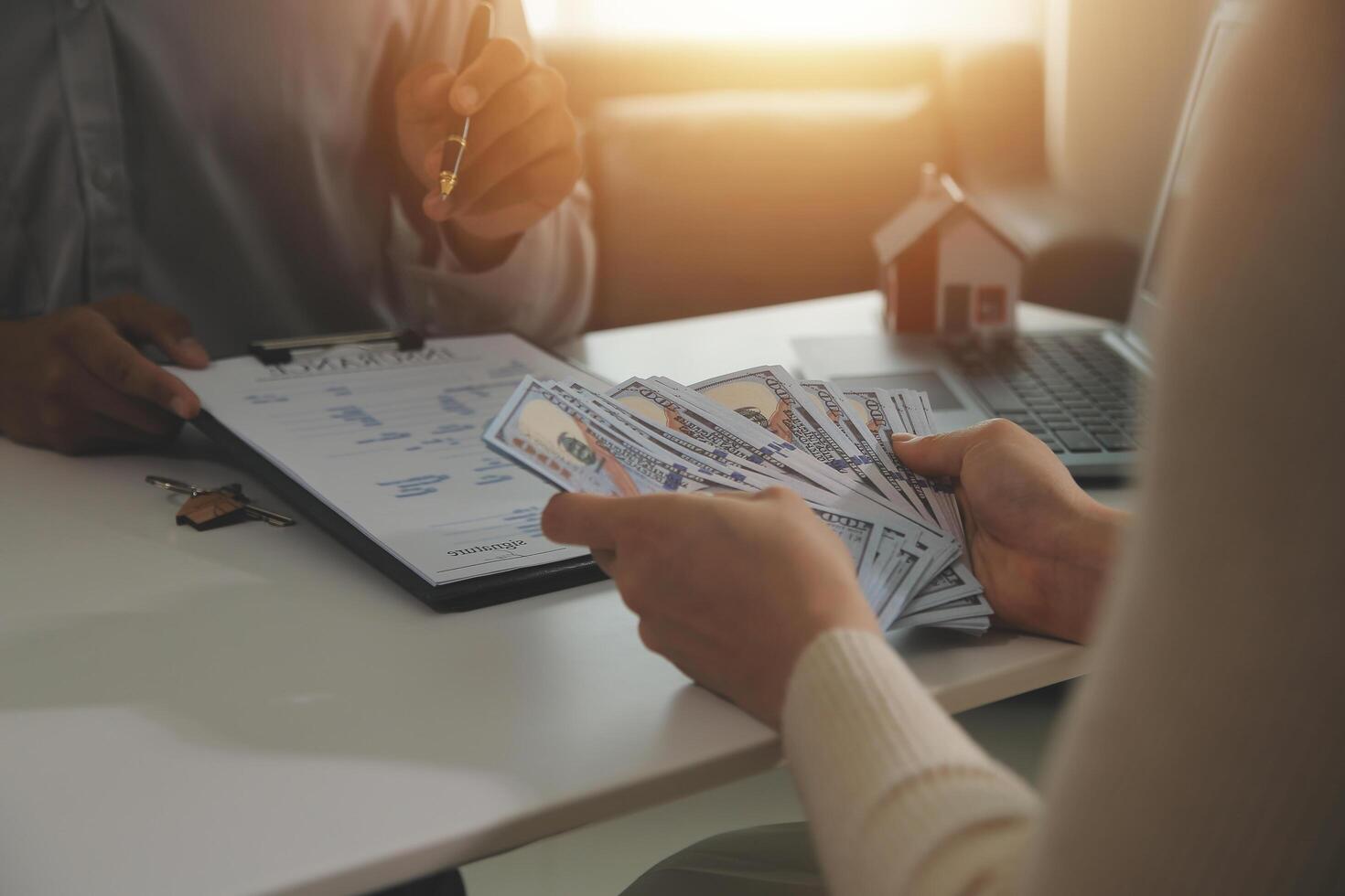 Real estate agent home sales broker is using a pen pointing to the house model and explains the business contract, rent, buy, mortgage, loan, or home insurance photo