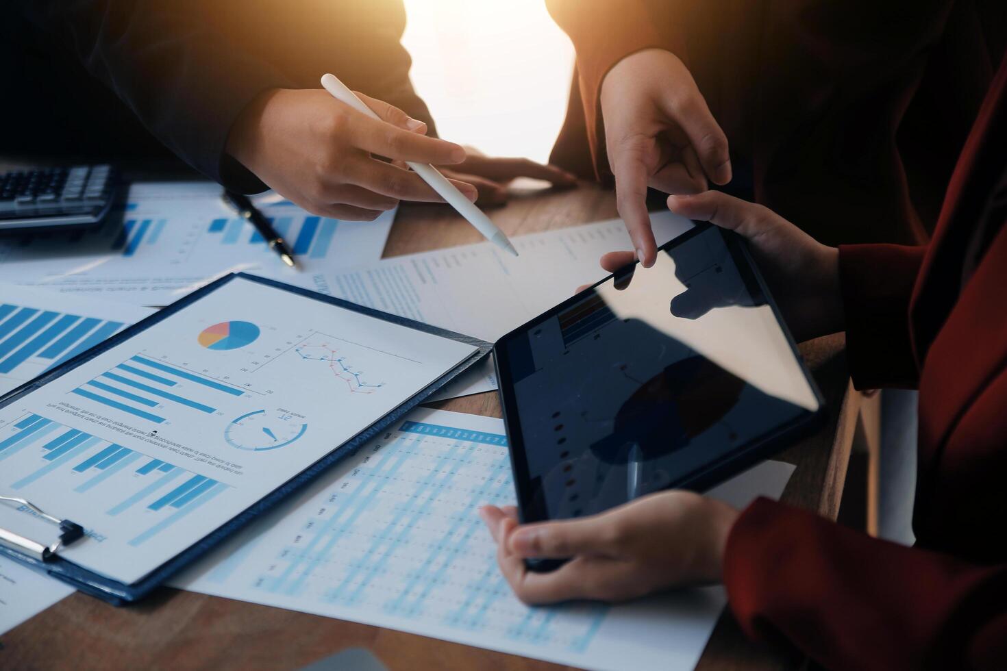 Group of confident business people point to graphs and charts to analyze market data, balance sheet, account, net profit to plan new sales strategies to increase production capacity. photo