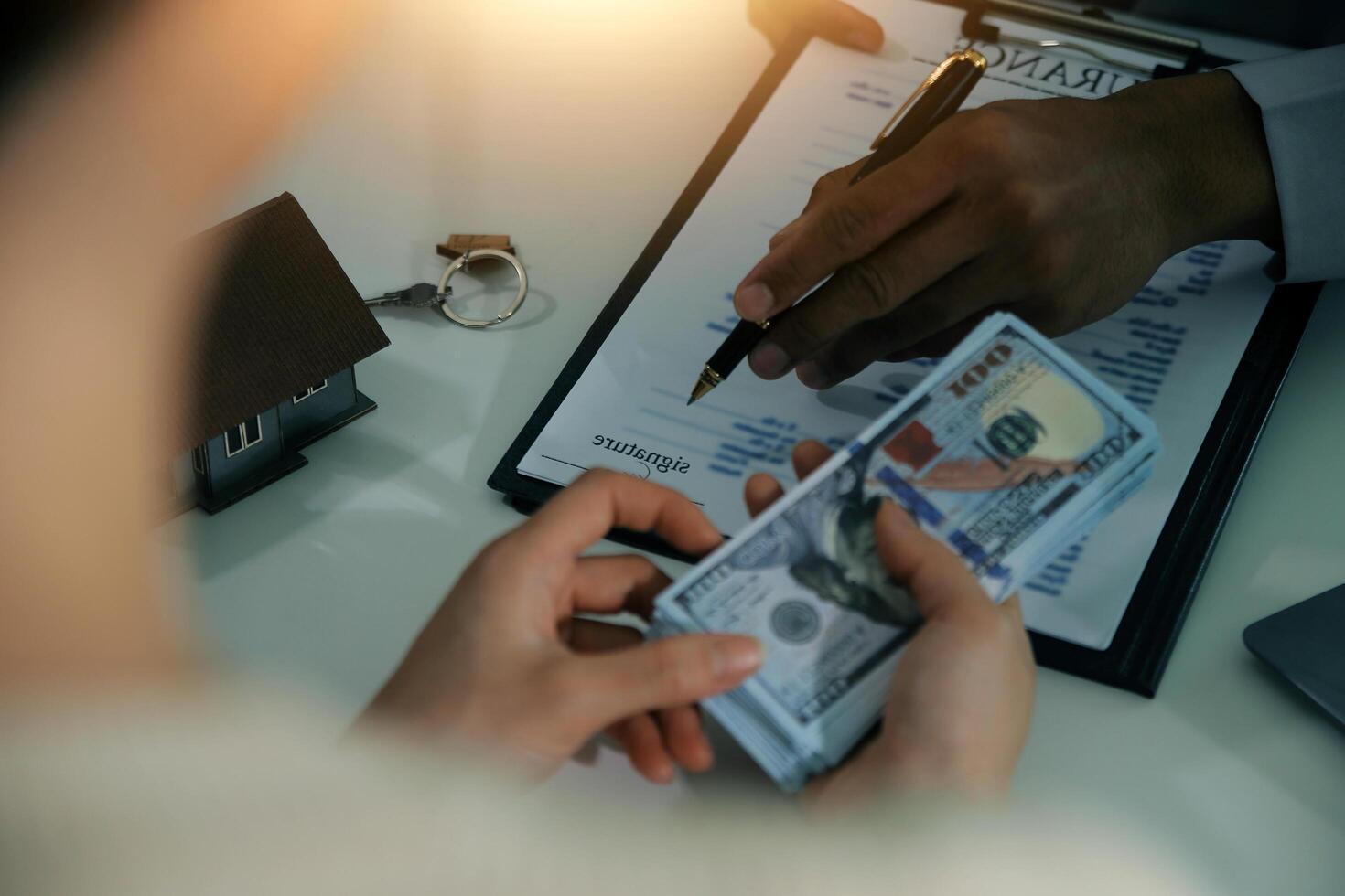 Real estate agent home sales broker is using a pen pointing to the house model and explains the business contract, rent, buy, mortgage, loan, or home insurance photo