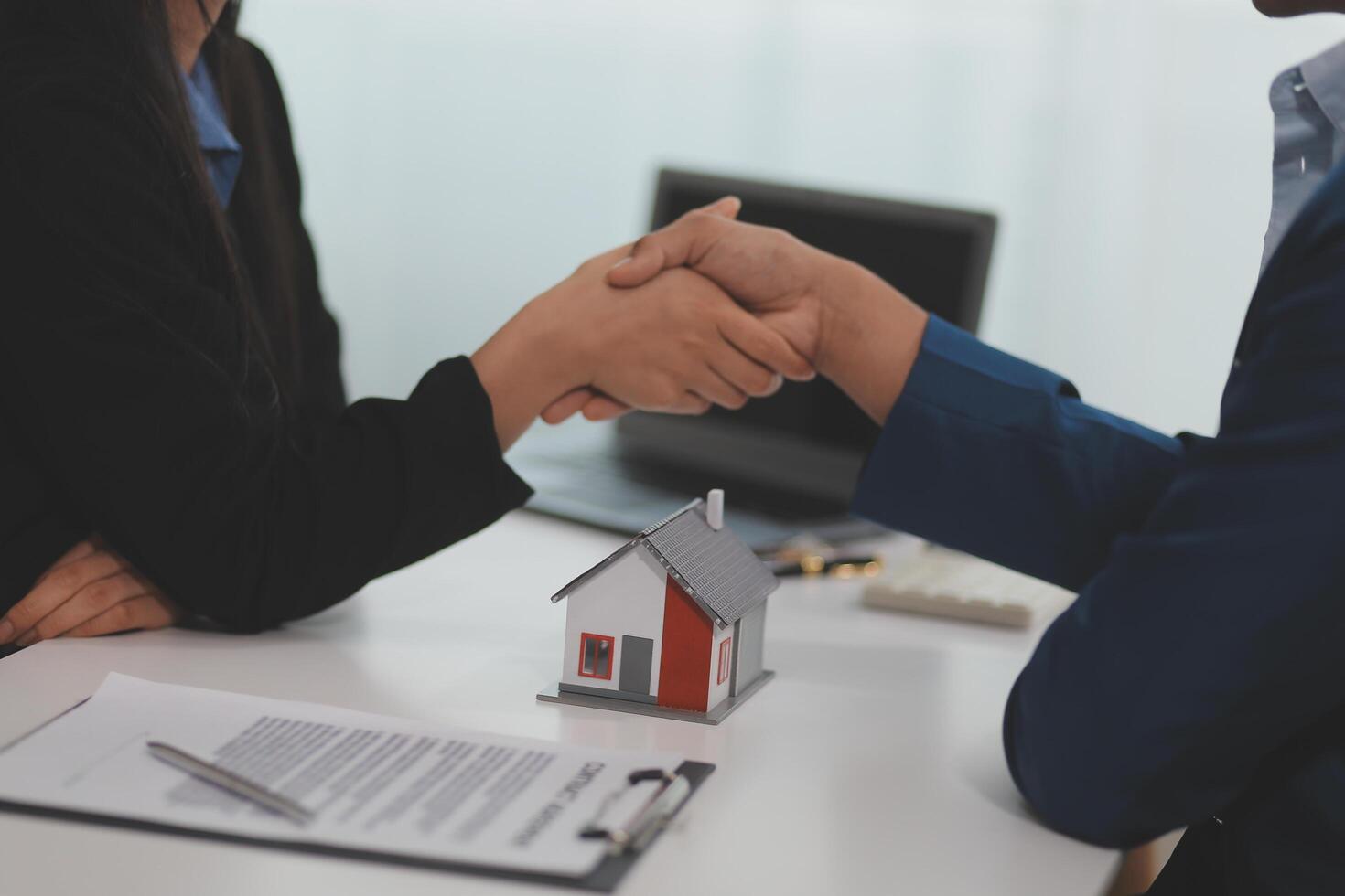 Estate agent shaking hands with customer after contract signature photo