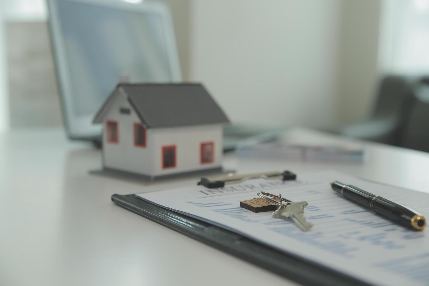 Real estate agent home sales broker is using a pen pointing to the house model and explains the business contract, rent, buy, mortgage, loan, or home insurance photo