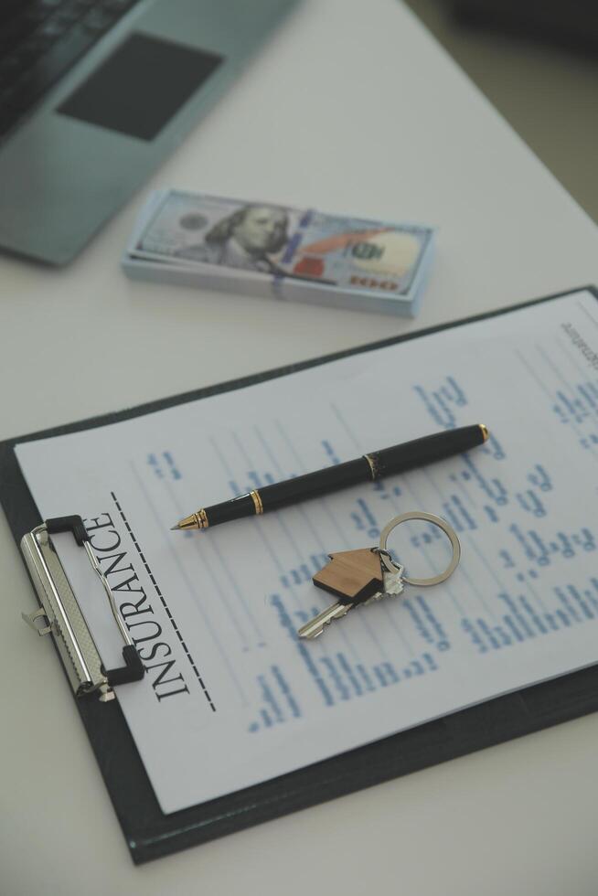 Real estate agent home sales broker is using a pen pointing to the house model and explains the business contract, rent, buy, mortgage, loan, or home insurance photo