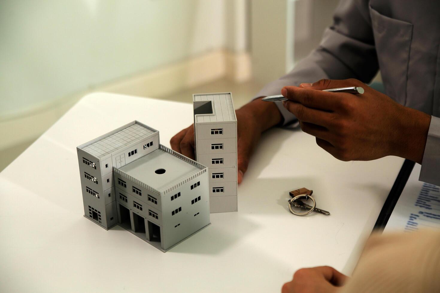 Real estate agent home sales broker is using a pen pointing to the house model and explains the business contract, rent, buy, mortgage, loan, or home insurance photo