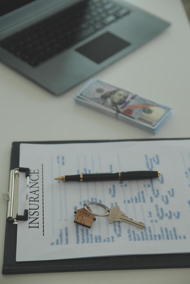 Real estate agent home sales broker is using a pen pointing to the house model and explains the business contract, rent, buy, mortgage, loan, or home insurance photo