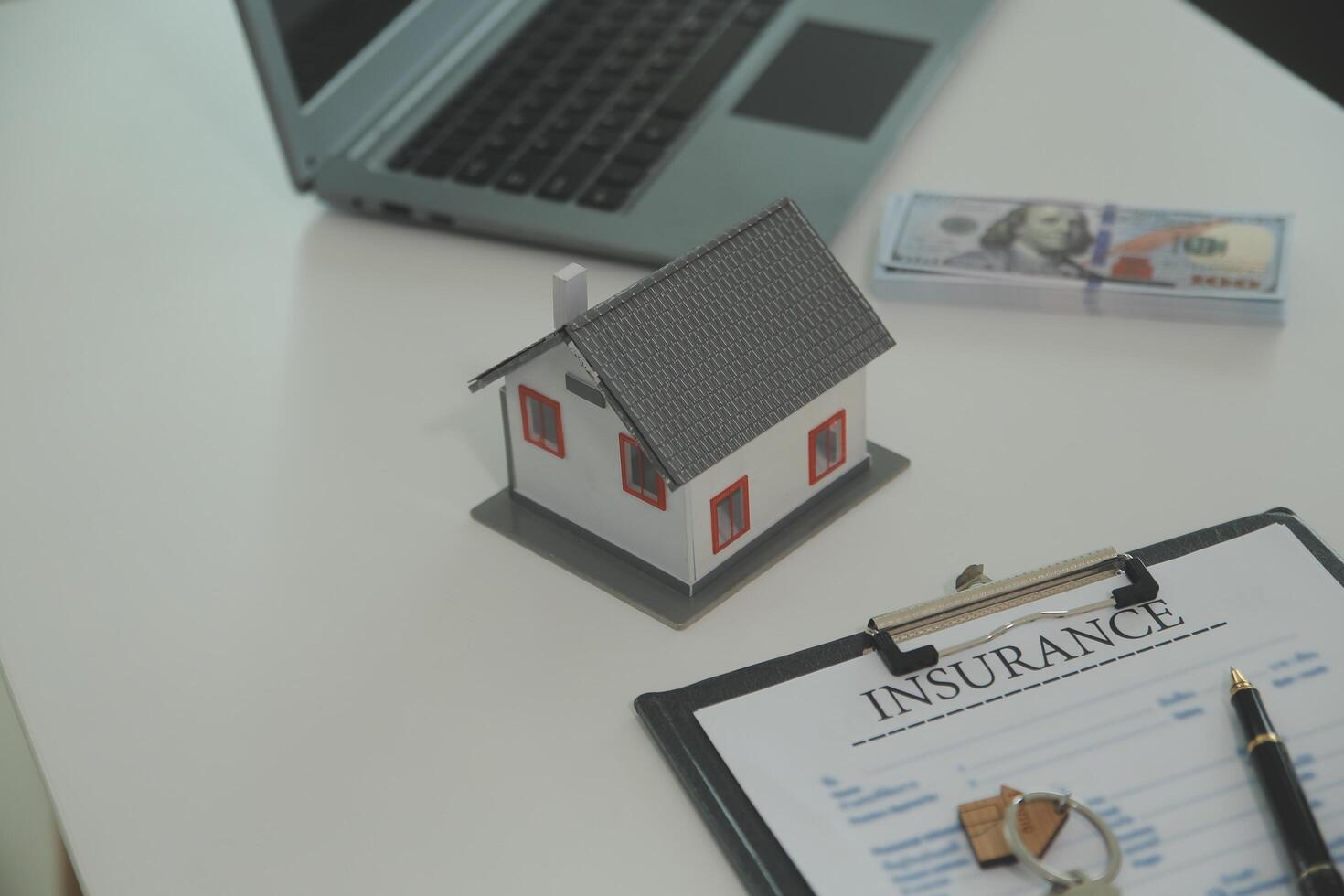 Real estate agent home sales broker is using a pen pointing to the house model and explains the business contract, rent, buy, mortgage, loan, or home insurance photo