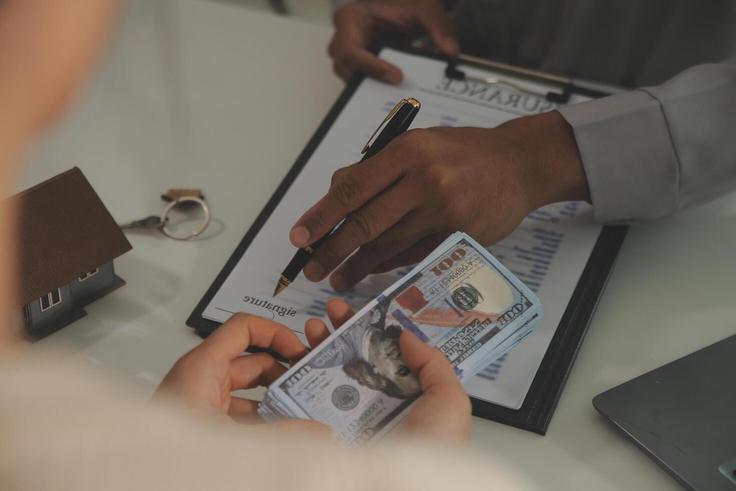 Real estate agent home sales broker is using a pen pointing to the house model and explains the business contract, rent, buy, mortgage, loan, or home insurance photo