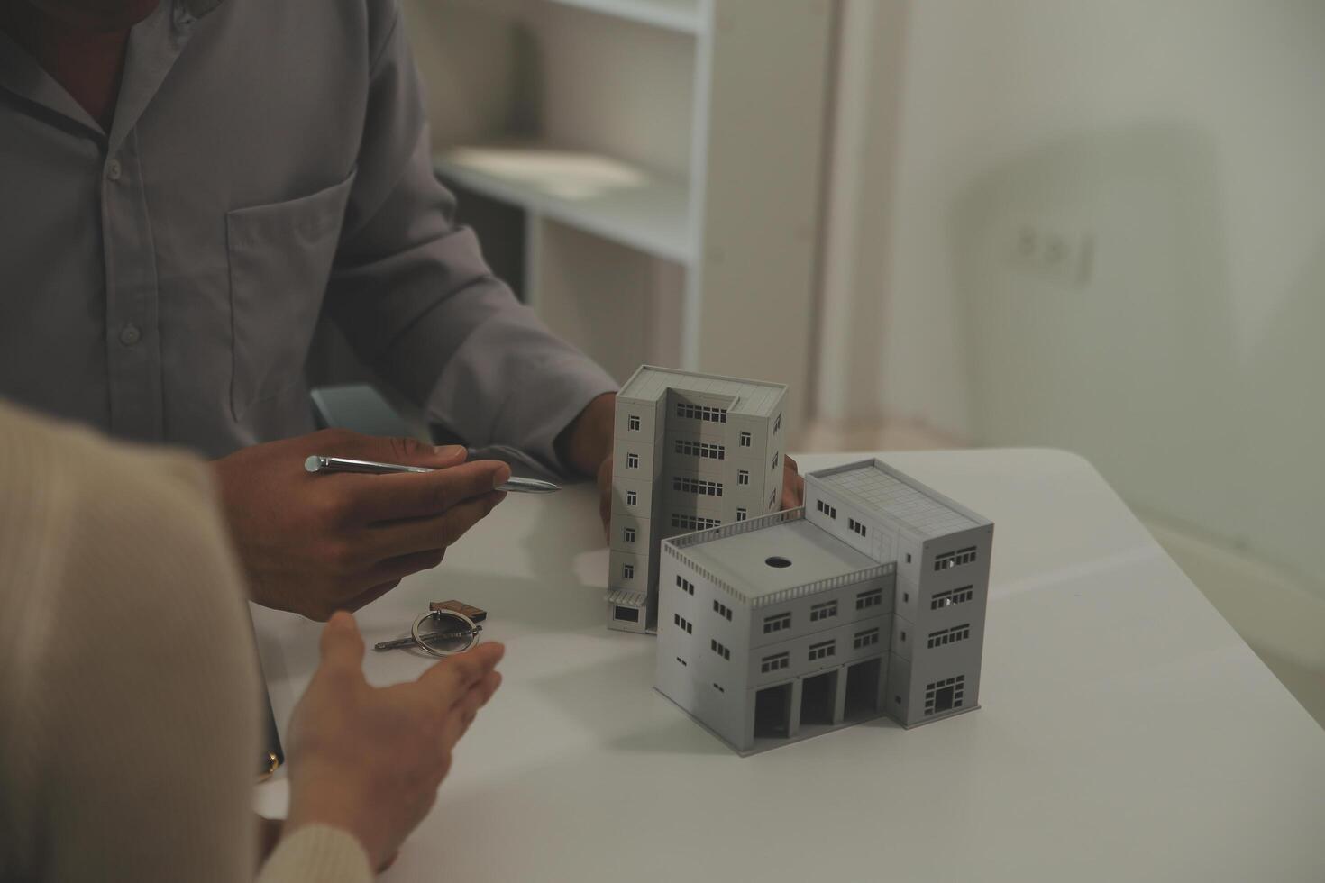 Real estate agent home sales broker is using a pen pointing to the house model and explains the business contract, rent, buy, mortgage, loan, or home insurance photo