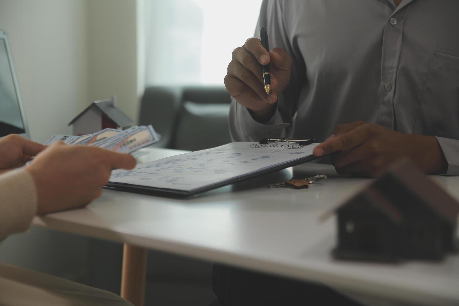 Real estate agent home sales broker is using a pen pointing to the house model and explains the business contract, rent, buy, mortgage, loan, or home insurance photo