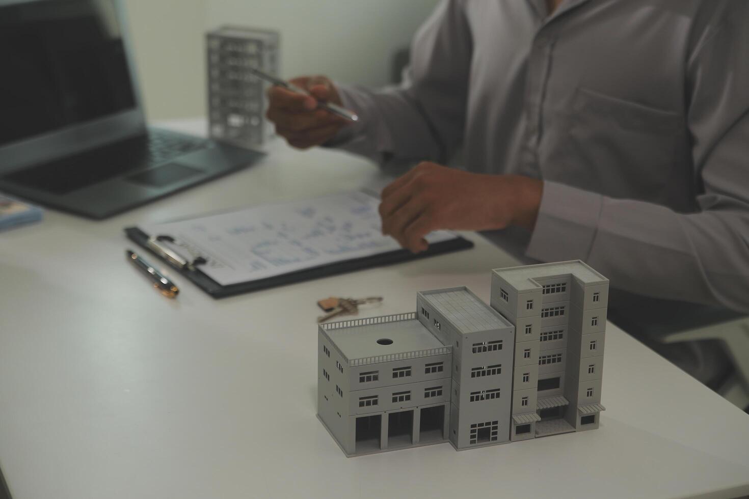 Real estate agent home sales broker is using a pen pointing to the house model and explains the business contract, rent, buy, mortgage, loan, or home insurance photo