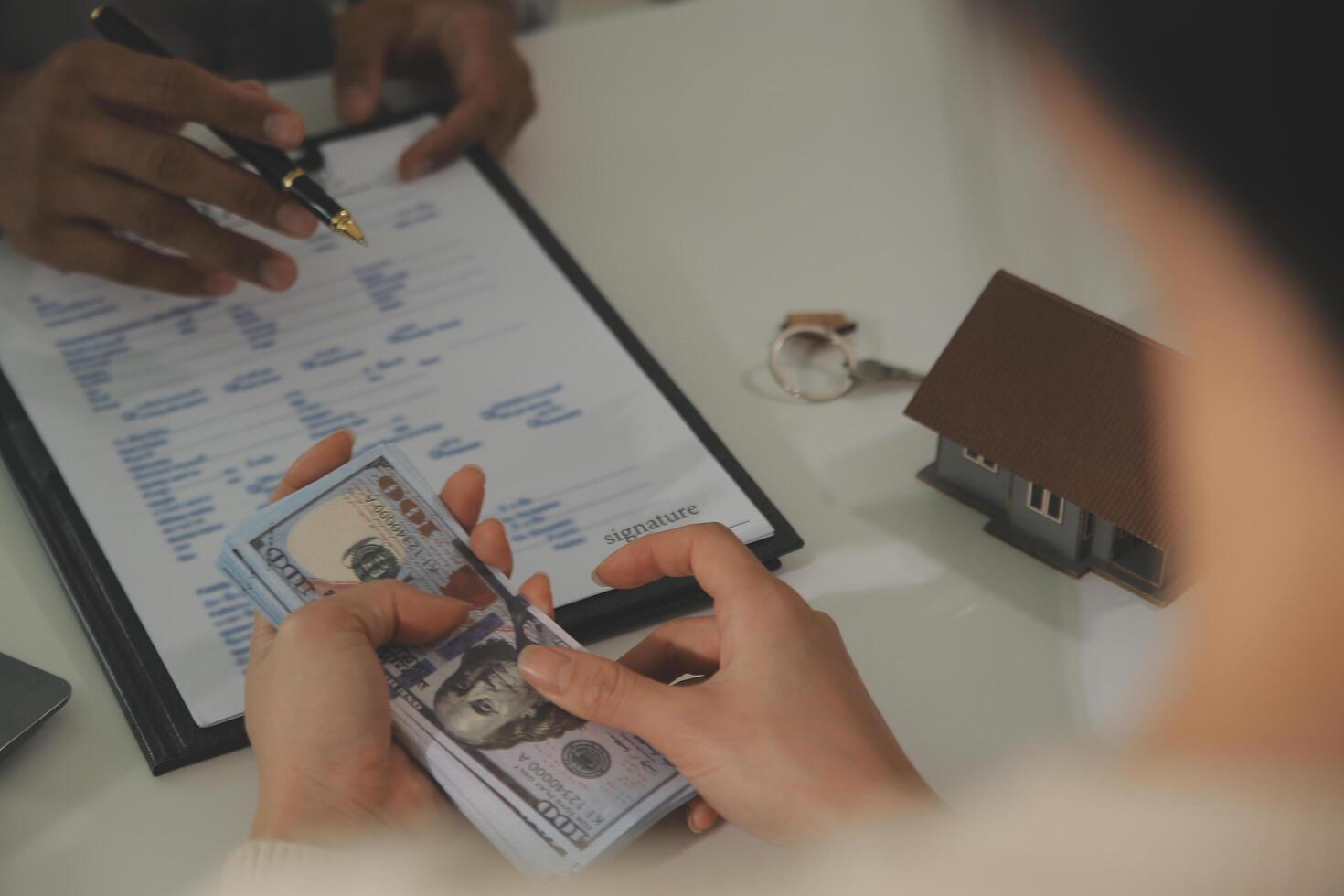 Real estate agent home sales broker is using a pen pointing to the house model and explains the business contract, rent, buy, mortgage, loan, or home insurance photo