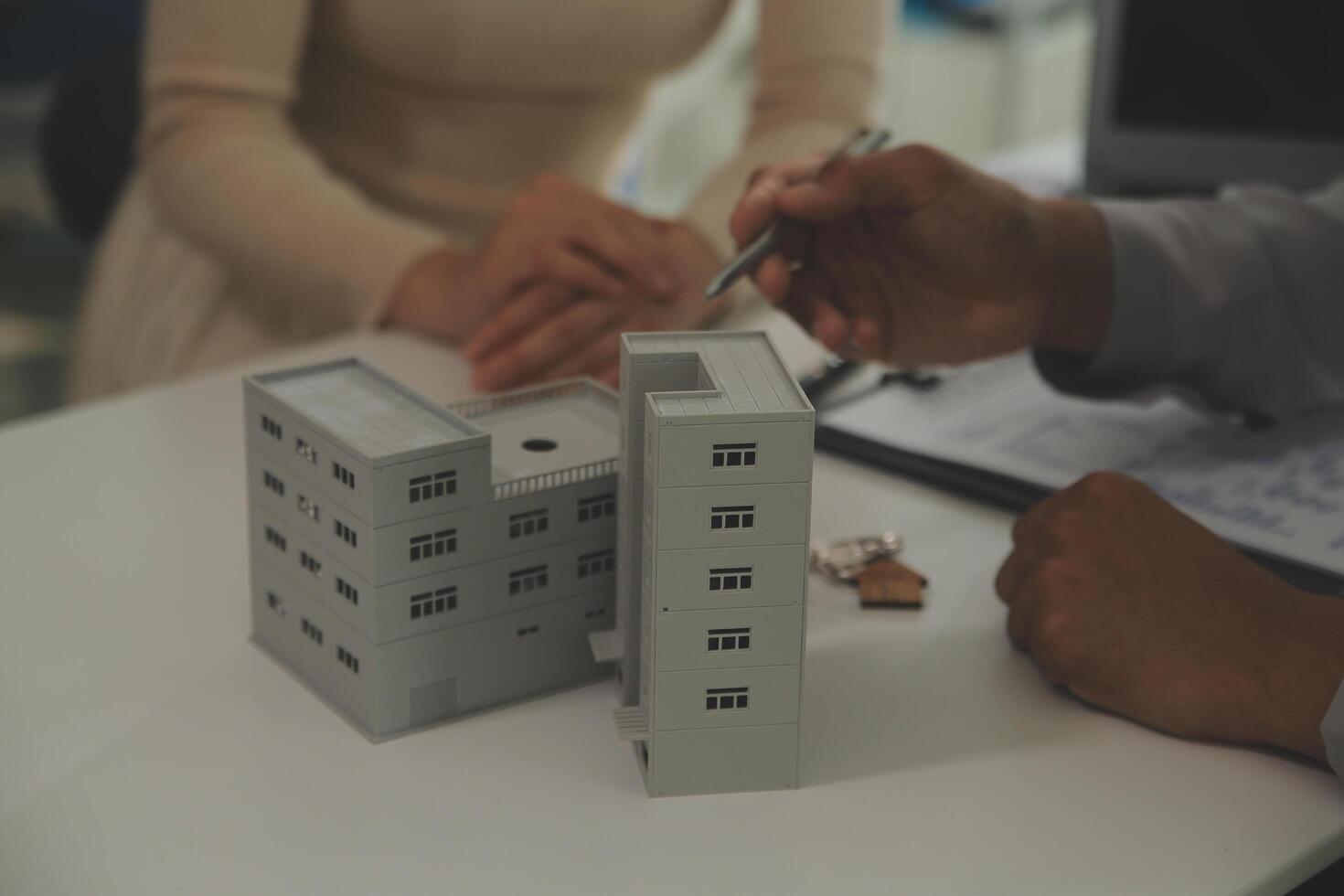 Real estate agent home sales broker is using a pen pointing to the house model and explains the business contract, rent, buy, mortgage, loan, or home insurance photo