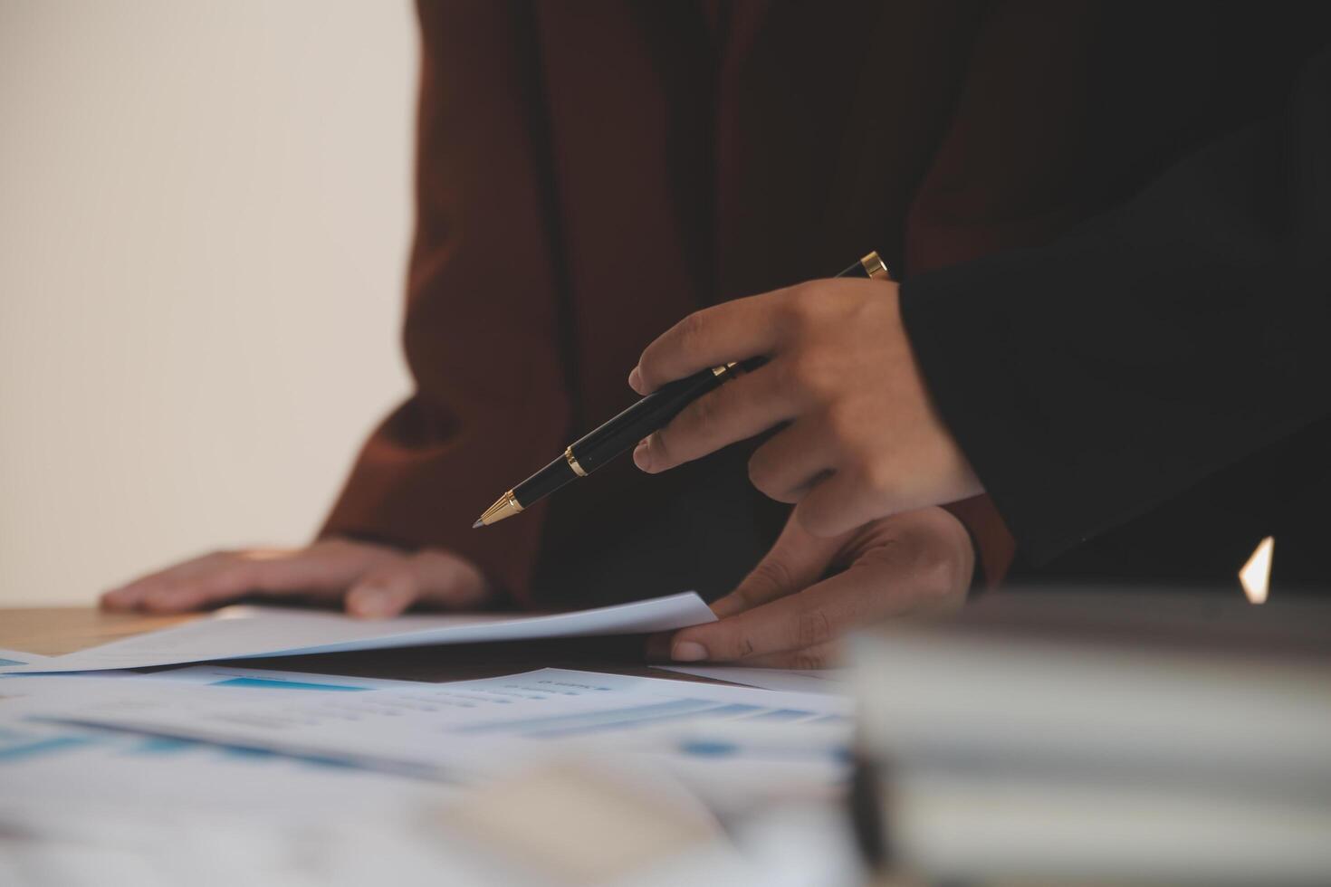 Group of confident business people point to graphs and charts to analyze market data, balance sheet, account, net profit to plan new sales strategies to increase production capacity. photo
