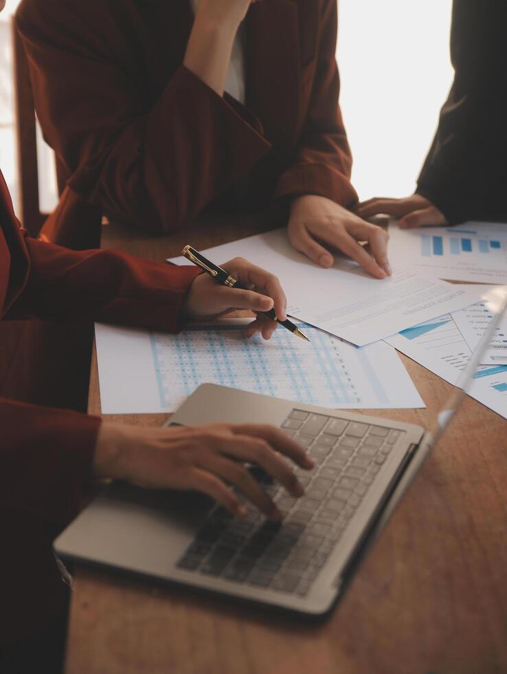 Group of confident business people point to graphs and charts to analyze market data, balance sheet, account, net profit to plan new sales strategies to increase production capacity. photo