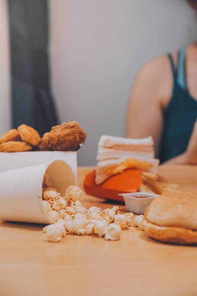 fast food, people and unhealthy eating concept - close up of woman hands holding hamburger or cheeseburger photo
