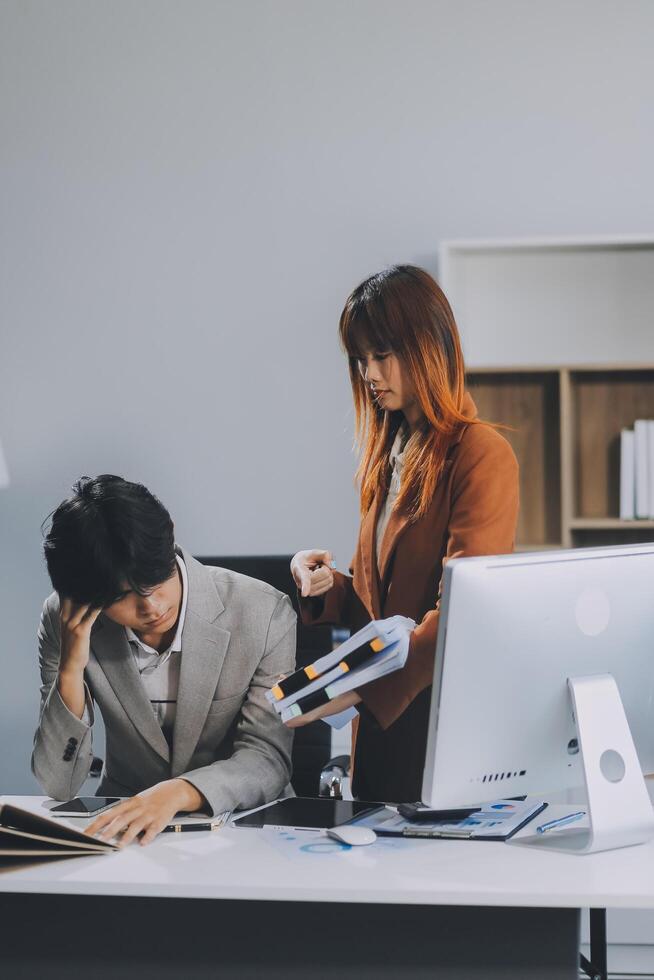 Stressed business couple working at big cabinet. Frustrated director closed face with hands at laptop workplace interior. Woman partner solving problems on smartphone call feeling nervous at office photo