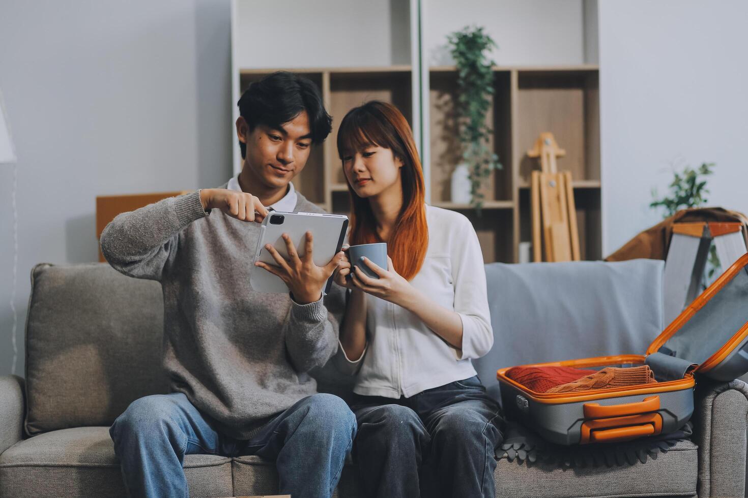 Young Asian couple relocating to a new house, joyfully packing and unpacking belongings. Expertise in moving, packing, togetherness, and creating a new home together. photo