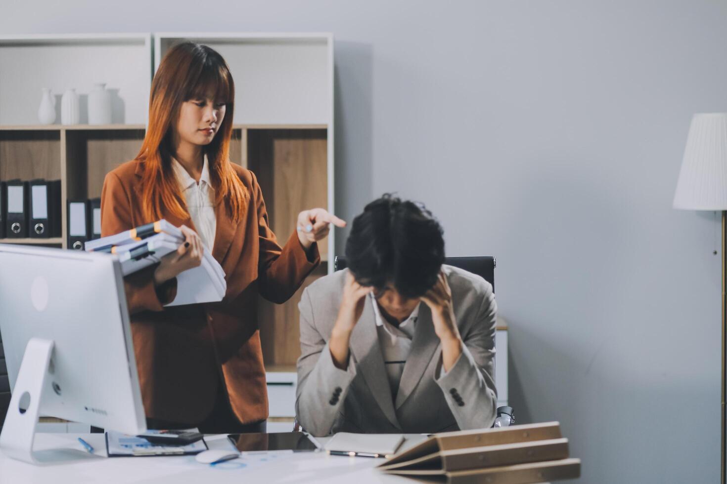 Stressed business couple working at big cabinet. Frustrated director closed face with hands at laptop workplace interior. Woman partner solving problems on smartphone call feeling nervous at office photo