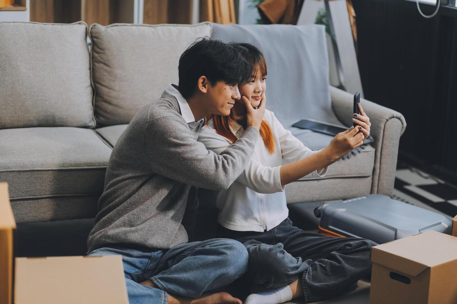 Young Asian couple relocating to a new house, joyfully packing and unpacking belongings. Expertise in moving, packing, togetherness, and creating a new home together. photo