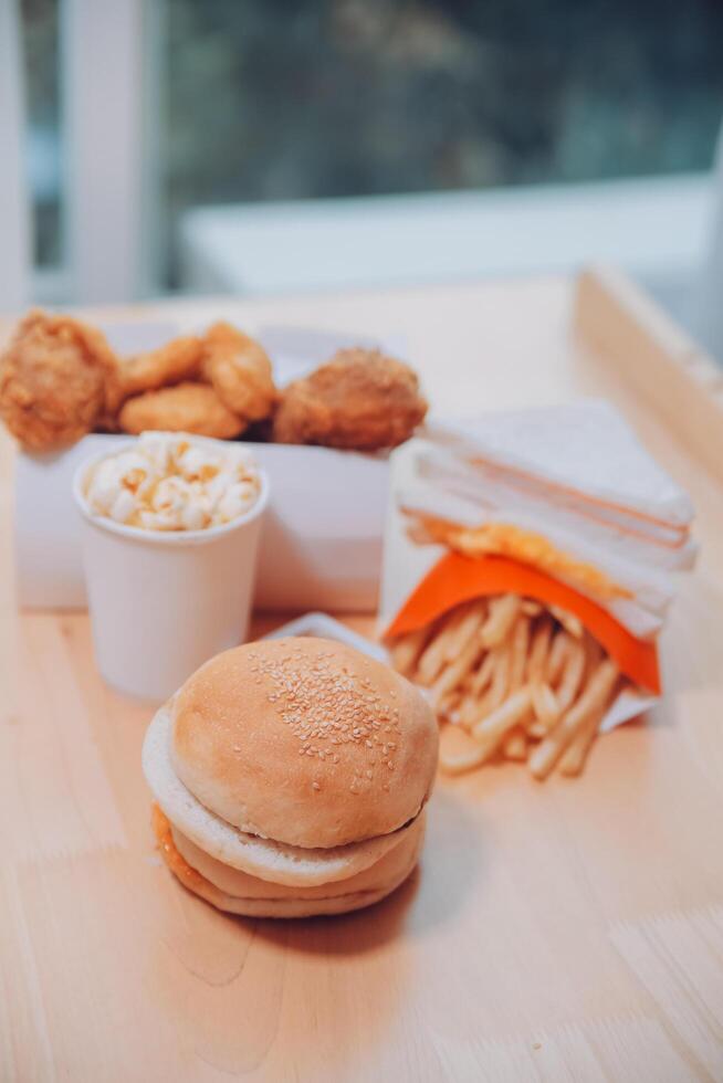 fast food, people and unhealthy eating concept - close up of woman hands holding hamburger or cheeseburger photo