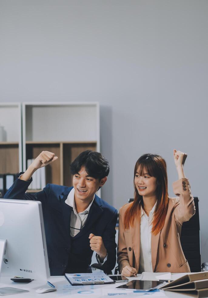 Entrepreneur Asian businessman and businesswoman discussing new business project in tablet in modern Meeting In Modern Office, Asian business casual concept. photo
