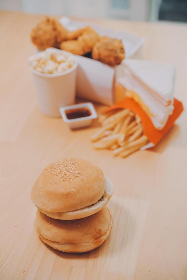 fast food, people and unhealthy eating concept - close up of woman hands holding hamburger or cheeseburger photo