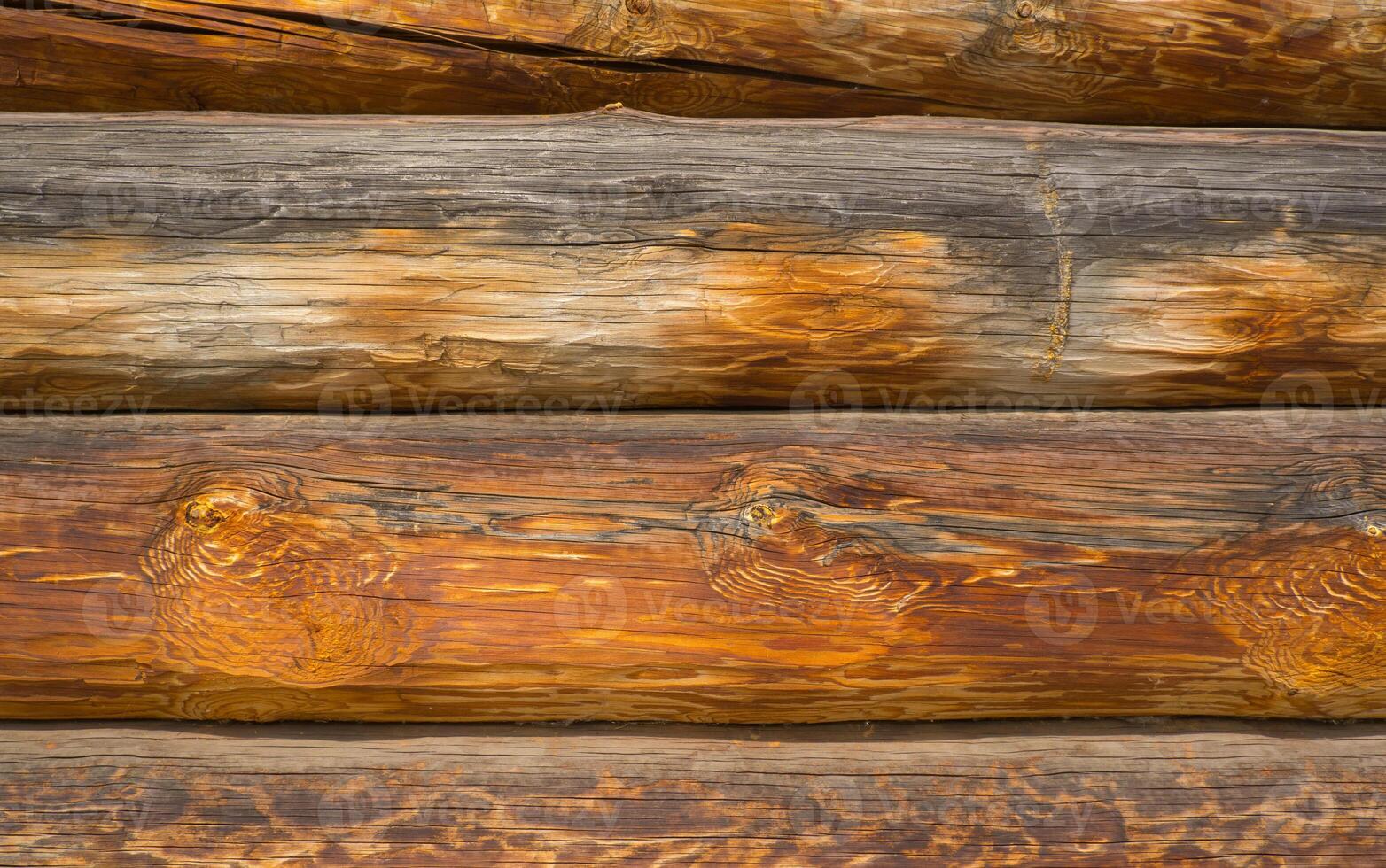 Wooden wall assembled from timber or logs. Background of horizontal logs. photo
