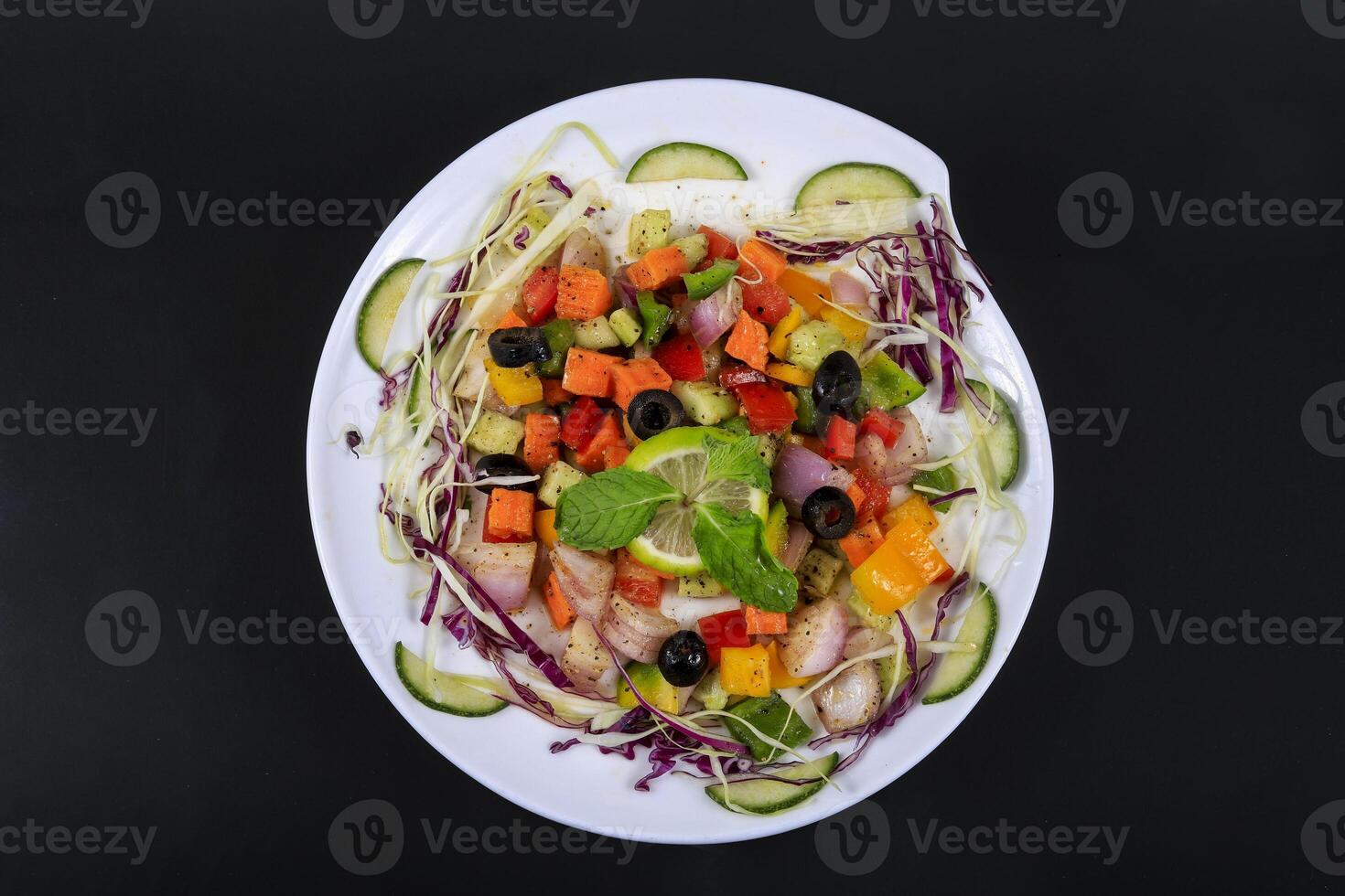 a plate of vegetables and meat on a black background photo