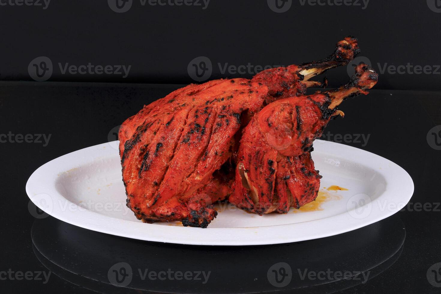 A plate with a large grilled chicken photo