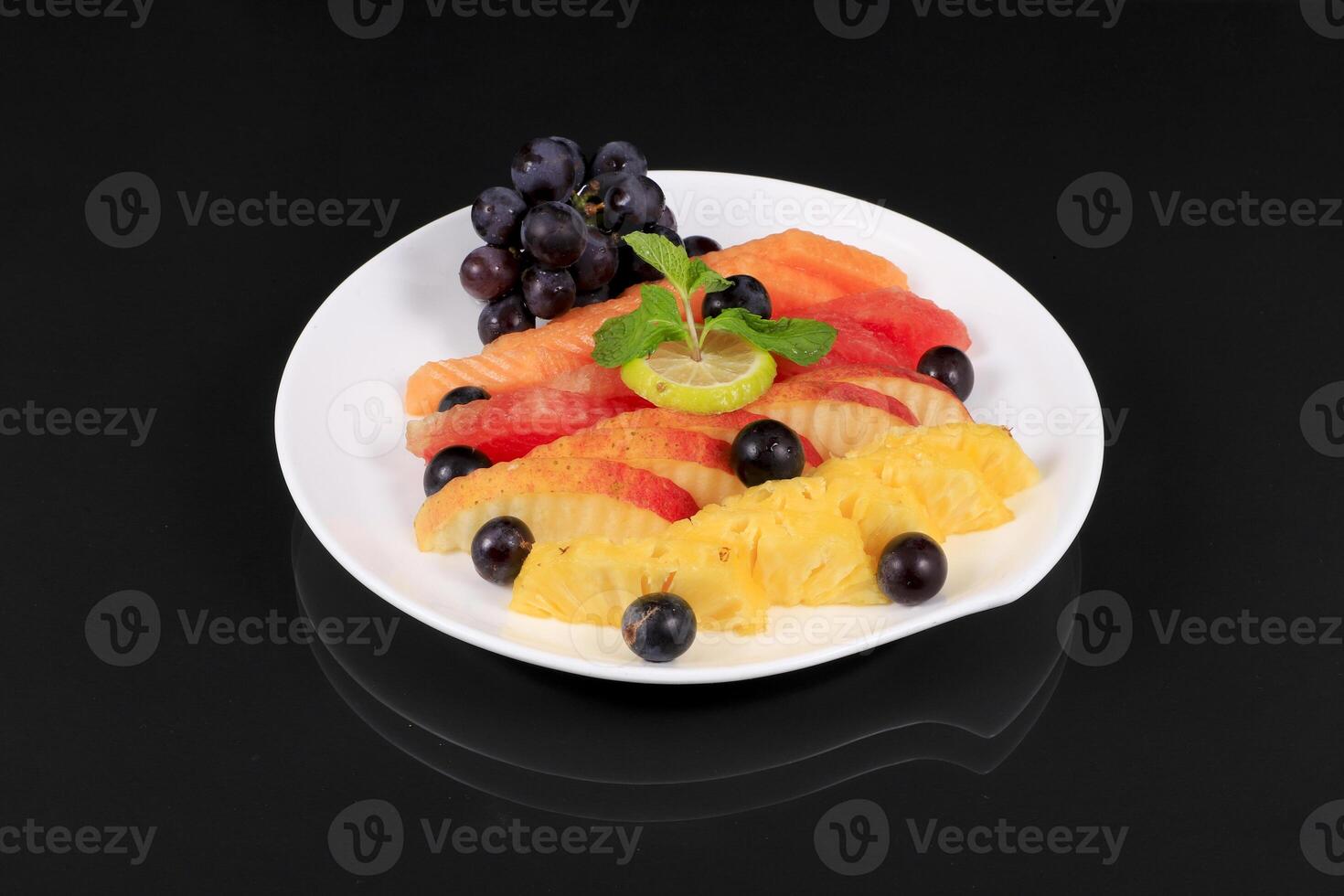 A plate of fruit with grapes, oranges, and lemons photo