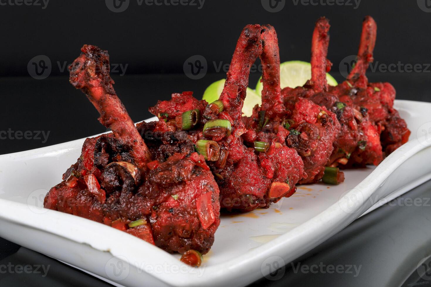 A plate with a Chicken lollipop on it photo