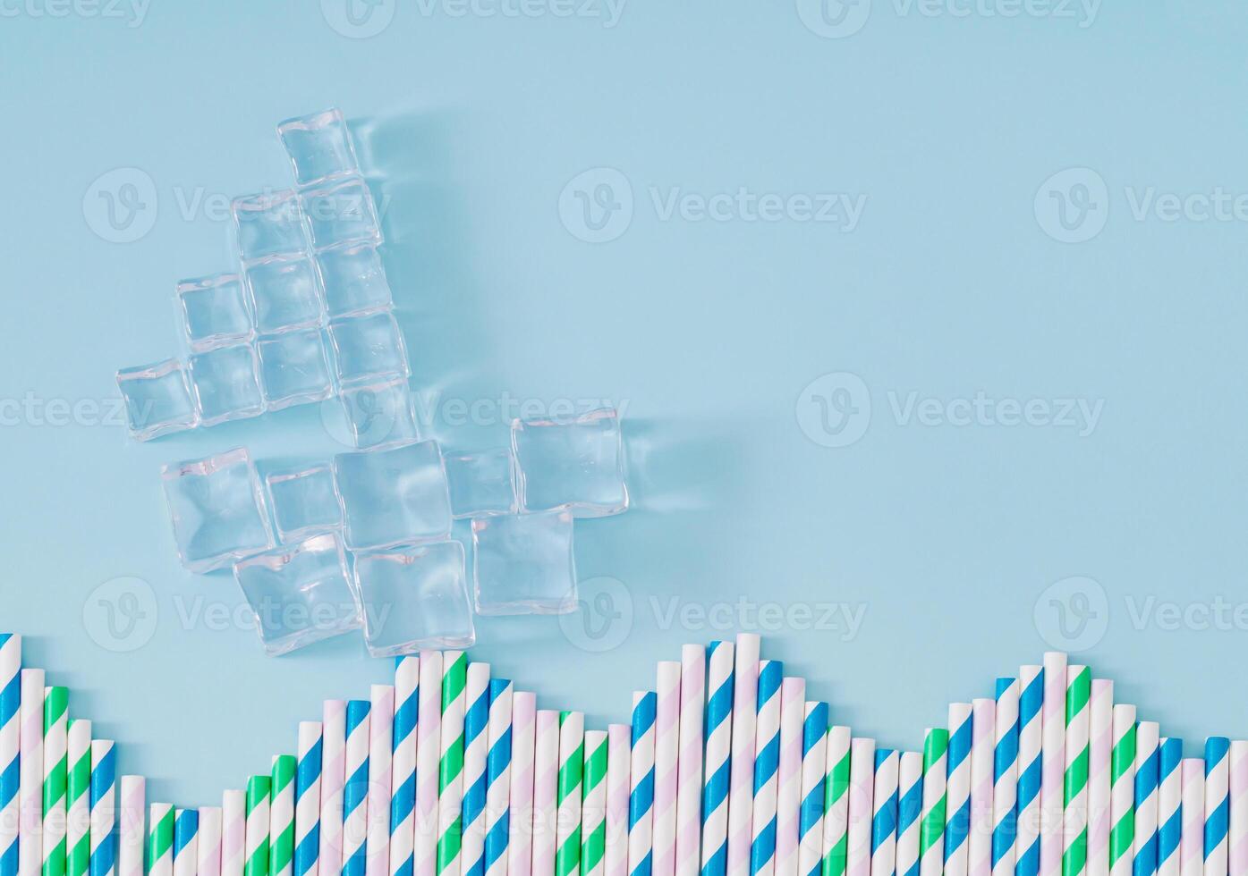 Sailing boat made of ice cubes traveling on sea made of drinking straws on pastel blue background. Minimal summer drink concept. Travel, vacation and summer journey pastel composition. Flat lay. photo