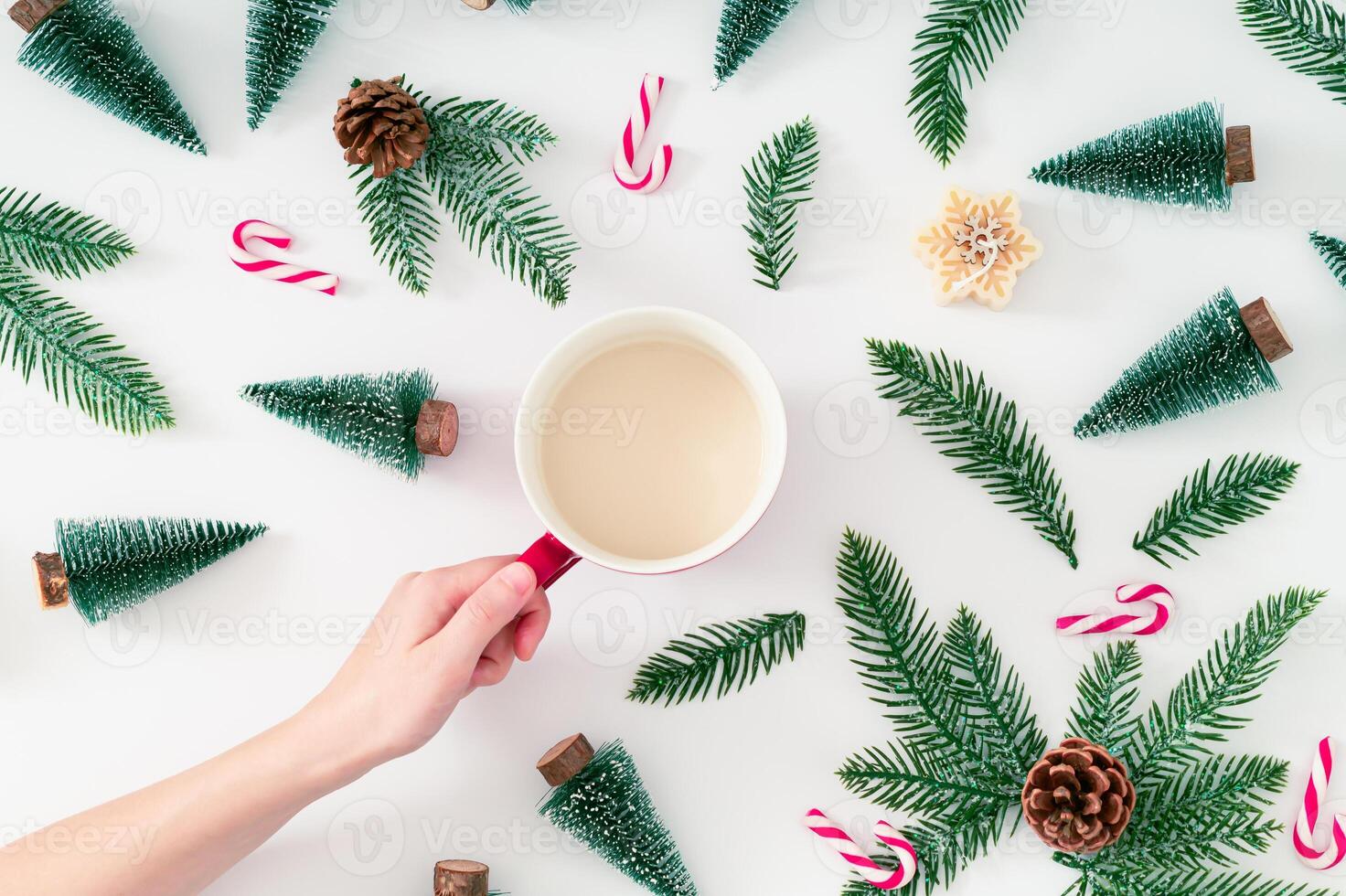 Christmas pattern made of green Xmas trees, snowy branches, candles, Christmas candies and pinecones with cup of coffee on white background. Creative Christmas and New Year concept. Winter flat lay. photo