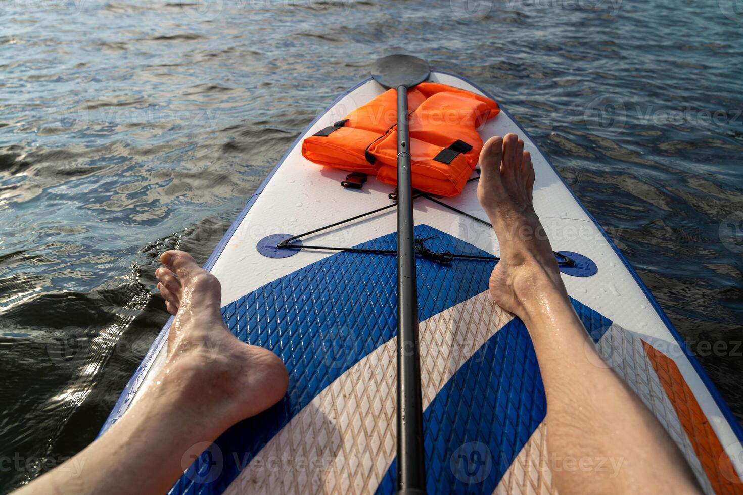 A person paddleboards while enjoying the serene water view photo