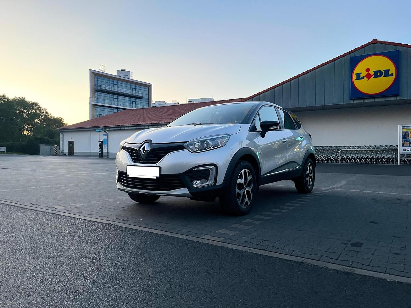 Poznan, Poland - 08.11.2024 Modern Renault Kaptur or Captur car parked outside a Lidl supermarket at sunset photo