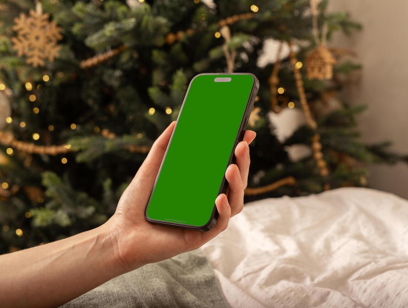 Lodz Poland July 20 2024 Hand holding mobile phone mockup, iphone screen mock up, Christmas holiday photo