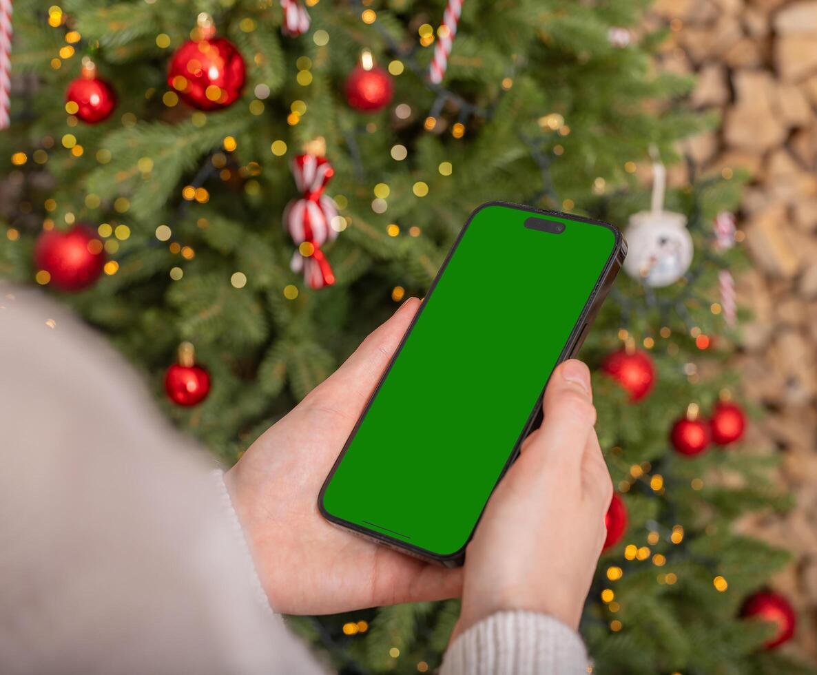 Lodz Poland July 20 2024 Hand holding mobile phone mockup, iphone screen mock up, Christmas holiday photo
