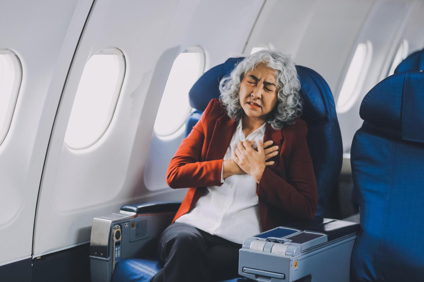 Mature with headache with nausea feeling sick while sitting in the airplane , Passengers near the window. photo