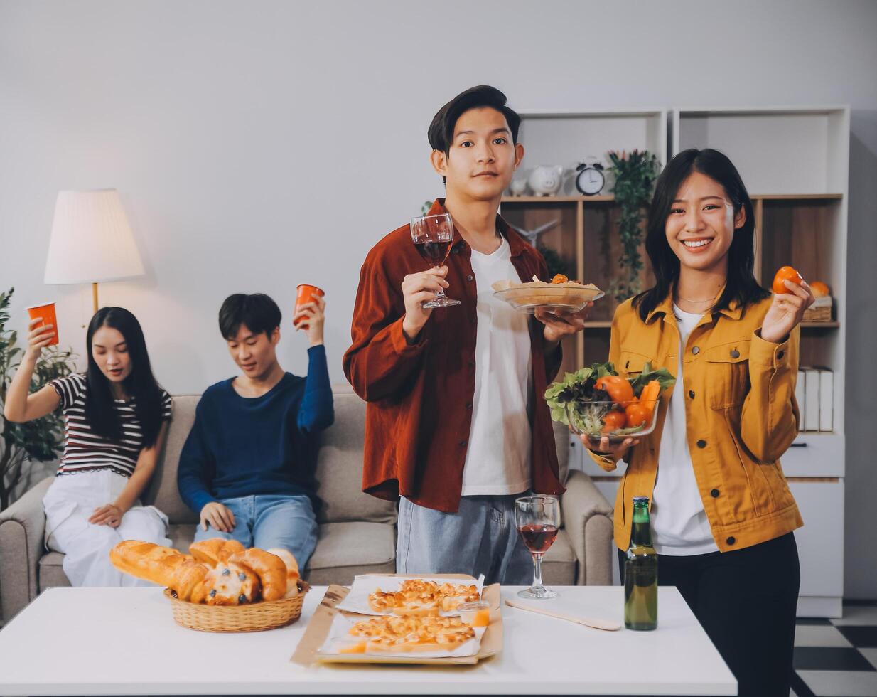 Happy friends making a toast with beer before eating pizza in a shared apartment. photo
